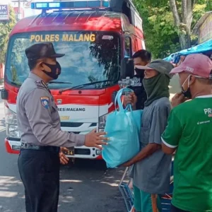 Anggota Polres Malang saat membagikan sembako kepada warga tidak mampu, Jum'at Berkah