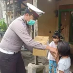 Anggota Satlantas Polres Batu saat memberikan Bantuan kepada anak yatim