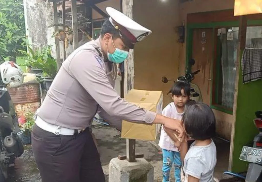 Anggota Satlantas Polres Batu saat memberikan Bantuan kepada anak yatim