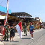 Babinsa Koramil 0808/20 Bersama Warga Pasang Bendera Setengah Tiang