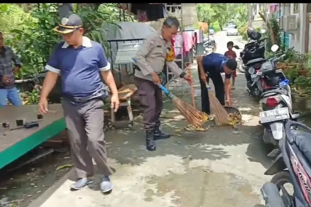 Potret Polri Peduli Sesama: Bhabinkamtibmas Kedoya Selatan Bantu Warga Bersihkan Sisa Banjir