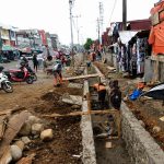 Posisi Proyek Pasar Panorama di Tengah Aktivitas KPK RI di Kota Bengkulu BENGKULU – Di tengah gelombang penggeledahan maraton Komisi Pemberantasan Korupsi (KPK) yang membidik dugaan ijon dan pengondisian proyek di Kota Bengkulu, muncul pertanyaan publik: mungkinkah pengerjaan drainase di kawasan Pasar Panorama ikut terseret dalam radar penyidikan lembaga antirasuah tersebut? Spekulasi ini mencuat setelah Organisasi Masyarakat Gerakan Bela Tanah Adat (GARBETA) Kota Bengkulu secara terbuka mendesak Aparat Penegak Hukum (APH) melakukan audit menyeluruh terhadap pengerjaan drainase Pasar Panorama. Proyek ini dinilai terkesan "siluman" dan ditutup-tutupi dari masyarakat. "Masyarakat berhak mengetahui proyek ini berasal dari mana dan menggunakan anggaran apa. Di lokasi tidak ada papan nama pengerjaan yang menjelaskan nilai anggaran, kontraktor pelaksana, maupun waktu pelaksanaan. Ini menimbulkan tanda tanya besar," ujar Ketua GARBETA Kota Bengkulu, Supli Hayadi. Ia menegaskan bahwa masyarakat tidak anti terhadap pembangunan daerah, namun penggunaan anggaran negara wajib dilaksanakan secara transparan dan dapat dipertanggungjawabkan sesuai asas tata kelola pemerintahan yang baik. Beririsan Langsung dengan Sektor SDA dan Dinas PUPR Potensi masuknya proyek drainase ini ke dalam pusaran pemeriksaan KPK sangat terbuka lebar. Pasalnya, pengerjaan drainase berada di bawah naungan Bidang Sumber Daya Air (SDA) dan Dinas PUPR Kota Bengkulu—dua pos anggaran yang saat ini menjadi episentrum penyidikan KPK. Lembaga antirasuah tercatat telah menyita 25 koper dokumen dan uang tunai lebih dari Rp4 miliar dari kediaman Kepala Dinas PUPR Kota Bengkulu Noprisman, Kabid SDA Agus Suhendra Wijaya, hingga pejabat teknis PPTK dan pihak swasta. Fokus penyidikan KPK yang berlandaskan Surat Perintah Penyidikan (Sprindik) umum melacak dugaan aliran suap dan pengondisian paket pekerjaan fisik lintas anggaran selama lima tahun terakhir (2019–2026). Plt Direktur Penyidikan KPK, Achmad Taufik Husein, sebelumnya telah memberi sinyal kuat mengenai meluasnya penyidikan ke berbagai pengerjaan fisik lain yang menggunakan modus serupa, dengan peluang penetapan tersangka baru. Dengan tidak adanya papan transparansi pada pengerjaan drainase Pasar Panorama, desakan audit dari GARBETA ini menjadi pemicu bagi APH maupun KPK untuk mendalami apakah pengerjaan tersebut juga mengindikasikan pola pengondisian proyek serupa. Hingga berita ini diturunkan, belum ada keterbukaan maupun keterangan resmi dari pihak pelaksana dan instansi dinas terkait mengenai perizinan serta sumber anggaran proyek drainase di kawasan Pasar Panorama tersebut.