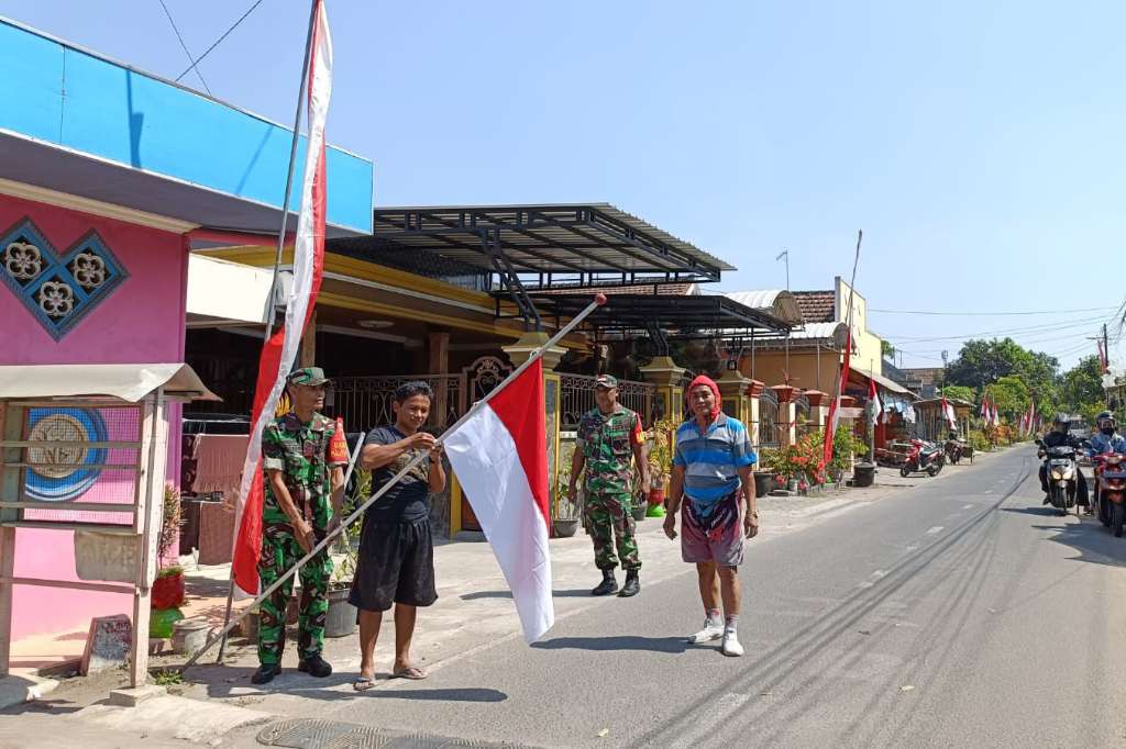 Babinsa Koramil 0808/20 Bersama Warga Pasang Bendera Setengah Tiang