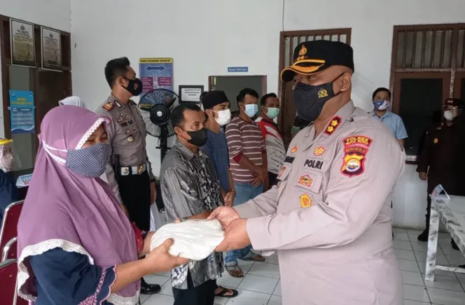 
					Kapolres Mukomuko menyerahkan beras kepada warga yang mengikuti vaksinasi