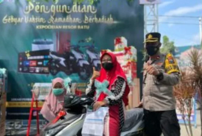 
					Kapolres Batu, AKBP I Nyoman Yogi Hermawan bersama seorang penerima hadiah sepeda motor, di Pos Yan Alun-alun Kota Batu, Malang.