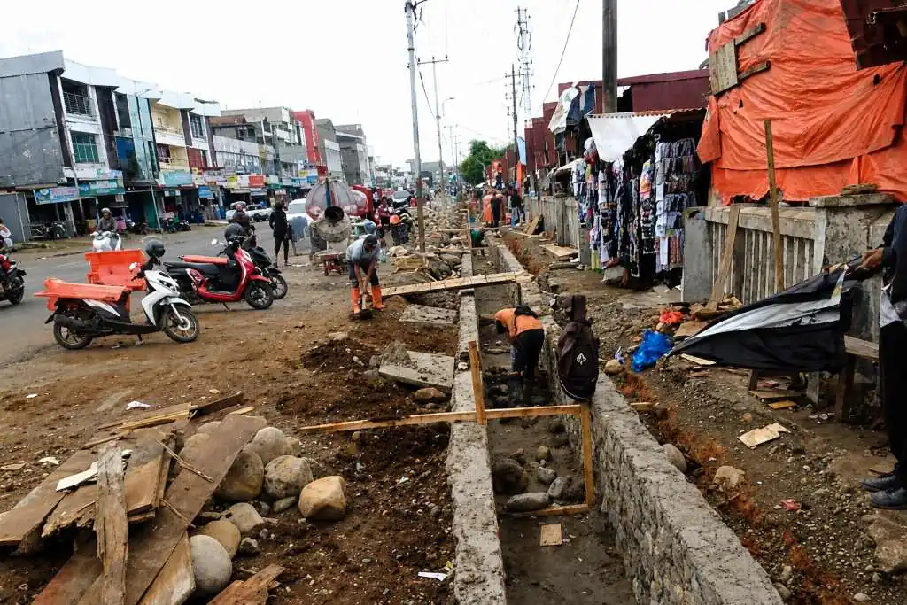 Posisi Proyek Pasar Panorama di Tengah Aktivitas KPK RI di Kota Bengkulu BENGKULU – Di tengah gelombang penggeledahan maraton Komisi Pemberantasan Korupsi (KPK) yang membidik dugaan ijon dan pengondisian proyek di Kota Bengkulu, muncul pertanyaan publik: mungkinkah pengerjaan drainase di kawasan Pasar Panorama ikut terseret dalam radar penyidikan lembaga antirasuah tersebut? Spekulasi ini mencuat setelah Organisasi Masyarakat Gerakan Bela Tanah Adat (GARBETA) Kota Bengkulu secara terbuka mendesak Aparat Penegak Hukum (APH) melakukan audit menyeluruh terhadap pengerjaan drainase Pasar Panorama. Proyek ini dinilai terkesan "siluman" dan ditutup-tutupi dari masyarakat. "Masyarakat berhak mengetahui proyek ini berasal dari mana dan menggunakan anggaran apa. Di lokasi tidak ada papan nama pengerjaan yang menjelaskan nilai anggaran, kontraktor pelaksana, maupun waktu pelaksanaan. Ini menimbulkan tanda tanya besar," ujar Ketua GARBETA Kota Bengkulu, Supli Hayadi. Ia menegaskan bahwa masyarakat tidak anti terhadap pembangunan daerah, namun penggunaan anggaran negara wajib dilaksanakan secara transparan dan dapat dipertanggungjawabkan sesuai asas tata kelola pemerintahan yang baik. Beririsan Langsung dengan Sektor SDA dan Dinas PUPR Potensi masuknya proyek drainase ini ke dalam pusaran pemeriksaan KPK sangat terbuka lebar. Pasalnya, pengerjaan drainase berada di bawah naungan Bidang Sumber Daya Air (SDA) dan Dinas PUPR Kota Bengkulu—dua pos anggaran yang saat ini menjadi episentrum penyidikan KPK. Lembaga antirasuah tercatat telah menyita 25 koper dokumen dan uang tunai lebih dari Rp4 miliar dari kediaman Kepala Dinas PUPR Kota Bengkulu Noprisman, Kabid SDA Agus Suhendra Wijaya, hingga pejabat teknis PPTK dan pihak swasta. Fokus penyidikan KPK yang berlandaskan Surat Perintah Penyidikan (Sprindik) umum melacak dugaan aliran suap dan pengondisian paket pekerjaan fisik lintas anggaran selama lima tahun terakhir (2019–2026). Plt Direktur Penyidikan KPK, Achmad Taufik Husein, sebelumnya telah memberi sinyal kuat mengenai meluasnya penyidikan ke berbagai pengerjaan fisik lain yang menggunakan modus serupa, dengan peluang penetapan tersangka baru. Dengan tidak adanya papan transparansi pada pengerjaan drainase Pasar Panorama, desakan audit dari GARBETA ini menjadi pemicu bagi APH maupun KPK untuk mendalami apakah pengerjaan tersebut juga mengindikasikan pola pengondisian proyek serupa. Hingga berita ini diturunkan, belum ada keterbukaan maupun keterangan resmi dari pihak pelaksana dan instansi dinas terkait mengenai perizinan serta sumber anggaran proyek drainase di kawasan Pasar Panorama tersebut.